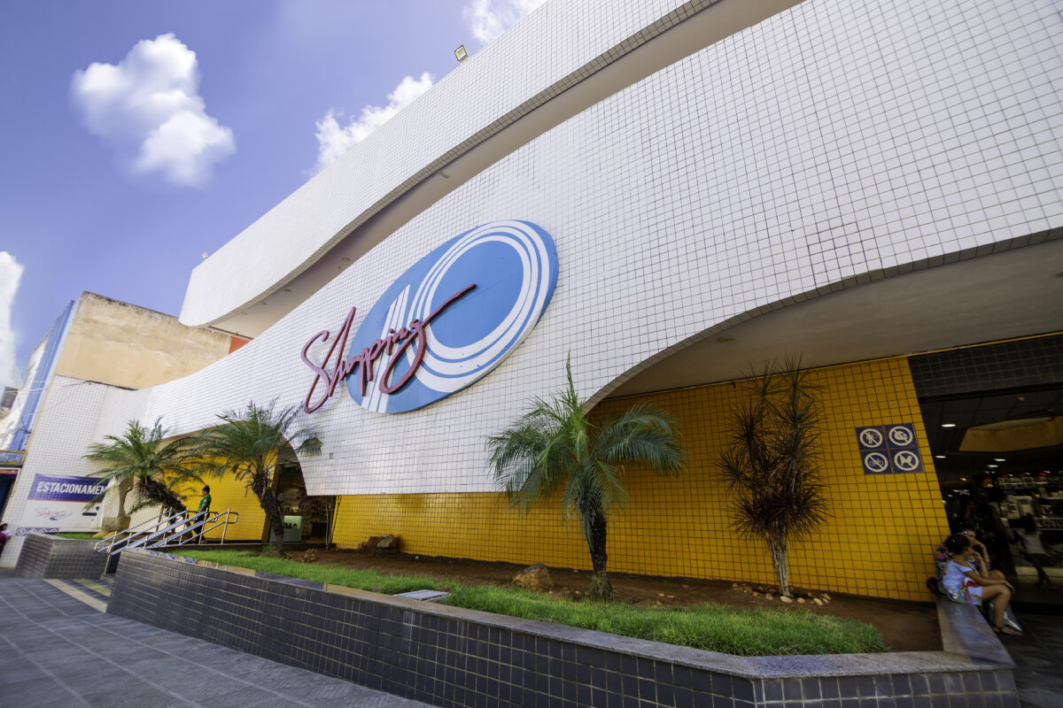 Fachada do Shopping 10 no bairro do Alecrim em Natal, com o logo azul e vermelho e paredes brancas e amarelas.